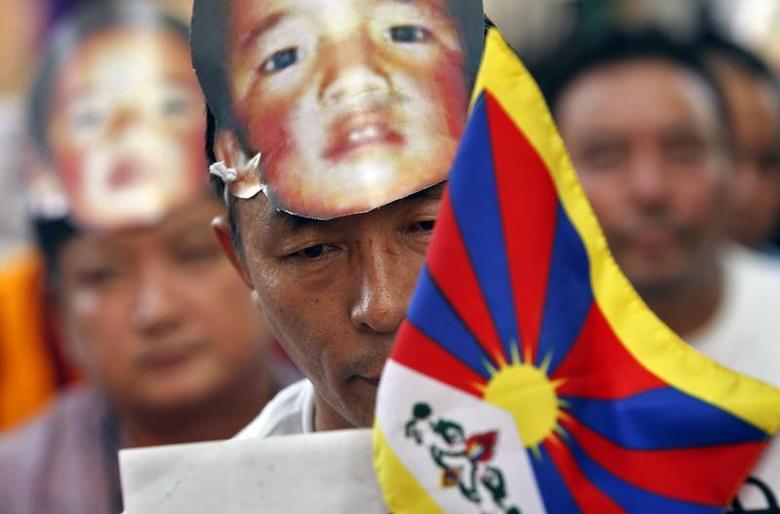 A Tibetan wearing a mask of Gedhun Choekyi Nyima during a protest. May 17 2013 (Photo - Reuters)
