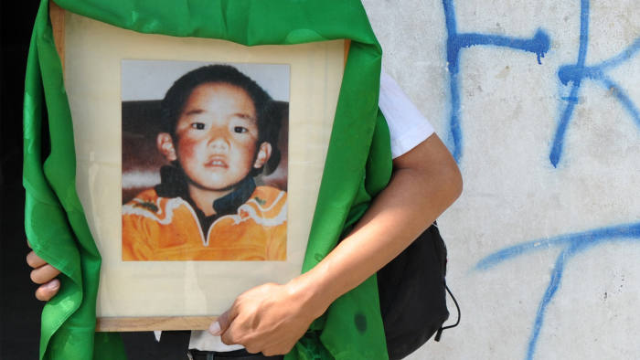 A man carries a portrait of the 11th Panchen Lama. Photo-Financial Times