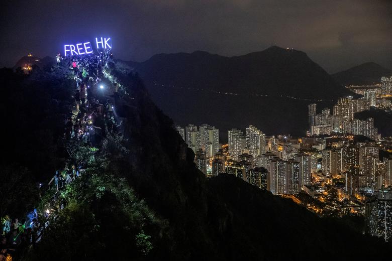 Hundreds of anti-government protestors gather at the peak of Lion Rock in Hong Kong as a lighted sign is held as a form of protest on Sep 13 2019 (Reuters)