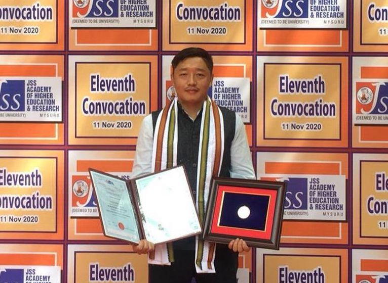 Pema Gyaltsen holding the medal at JJS University in Mysore (Phayul Photo)