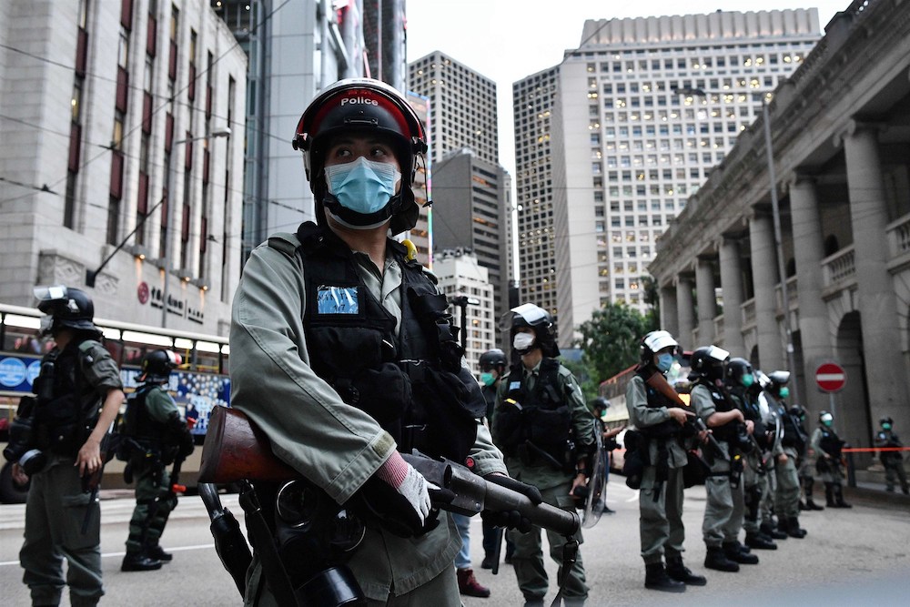 Police stand guard ahead of a pro-democracy march in Hong Kong in June (AFP)