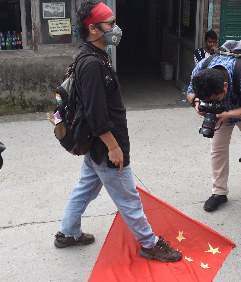 Tibetan activist Tenzin Tsundue stomp on the Chinese flag to protest against the border incursion in Ladakh by PLA forces (Phayul photo Kunsang Gashon)