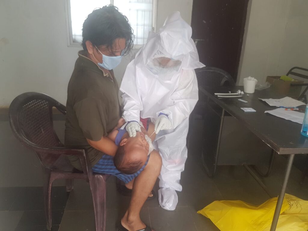 A father and son being tested for Covid-19 by a Tibetan health care workers in Doeguling settlement (Photo-DTR hospital, Mundgod)