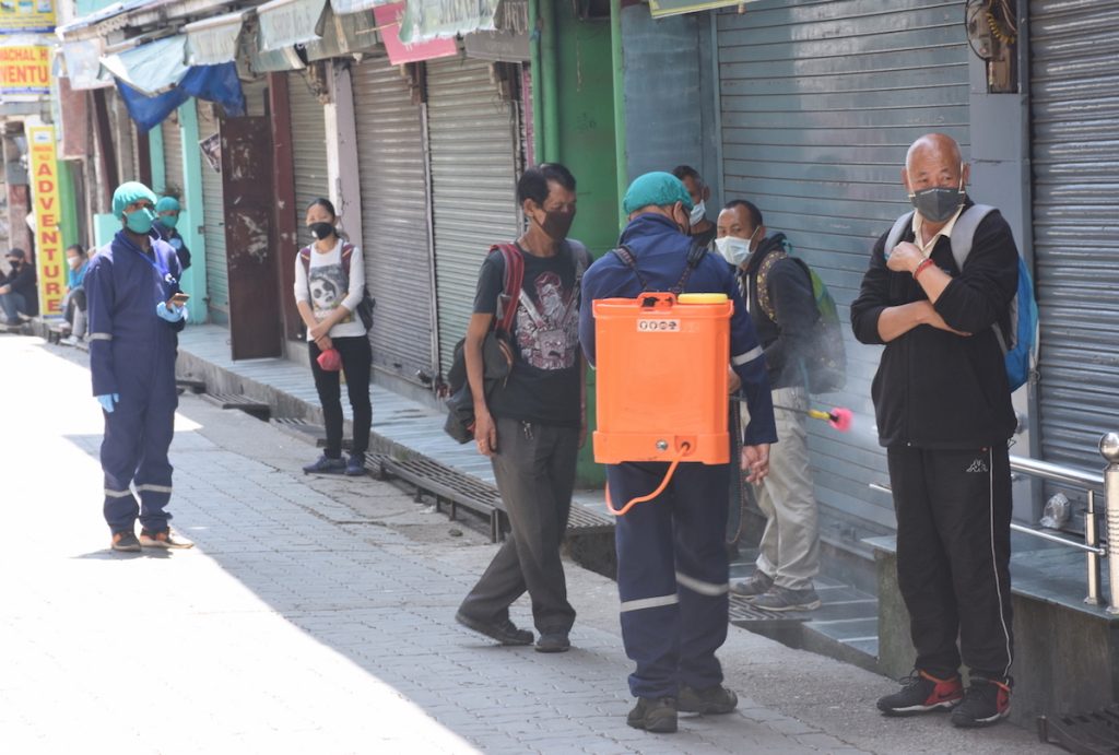 A worker sprays disinfectant in the streets of McLoed Ganj. May 1, 2020. Phayul photo-Kunsang Gashon